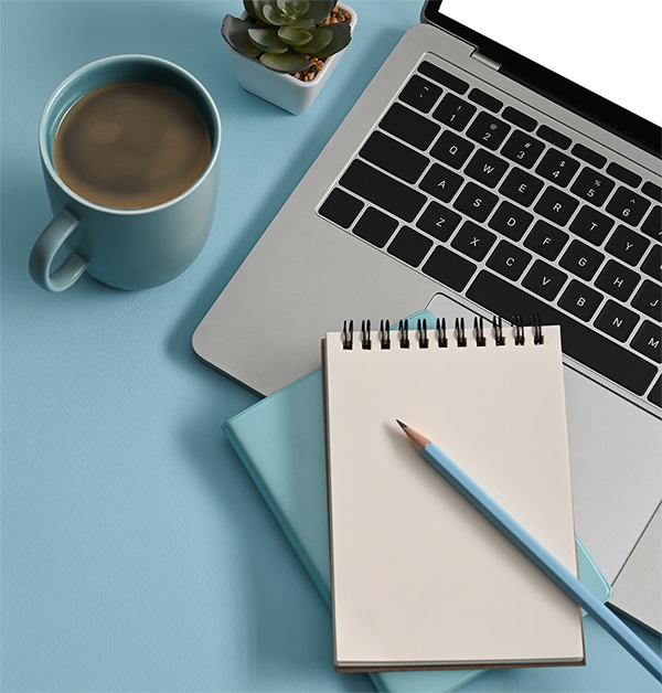 Laptop, notebook, and coffee arranged for technical documentation work